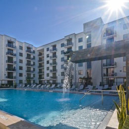 Two resort-style pools. a pool in front of a white building