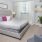 a bedroom with a bed and a fan and a window